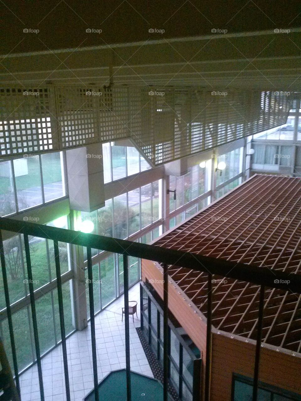 at the railing of a hotel's indoor balcony