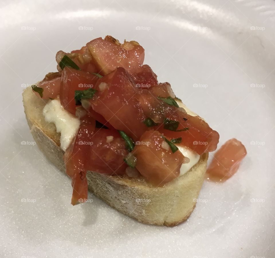 Homemade Mouthwatering Bruschetta with melted cheese 🧀 served on French bread with fresh basil 