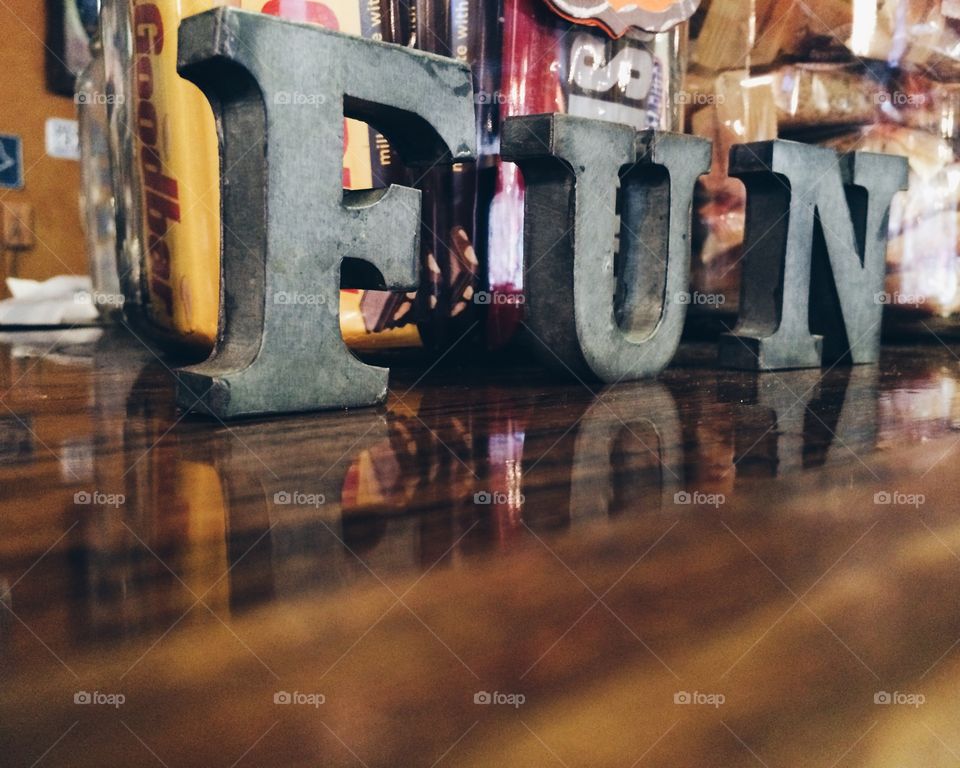 Fun with candy. Fun sign on wooden countertop with candy jars in background. 