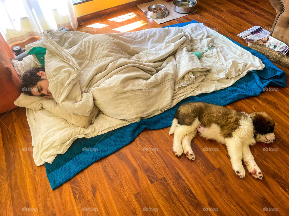Boy sleeping with his puppy 