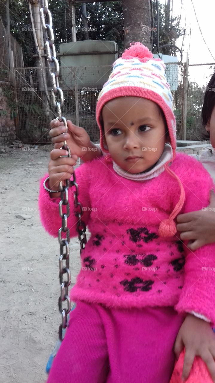 Little girl sitting on swings