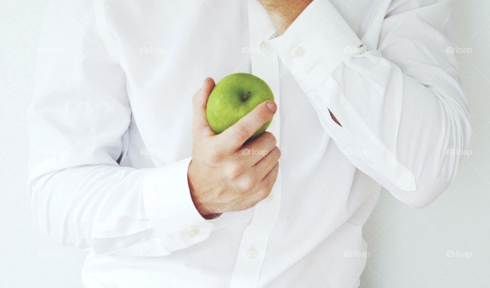 A man holding a green apple