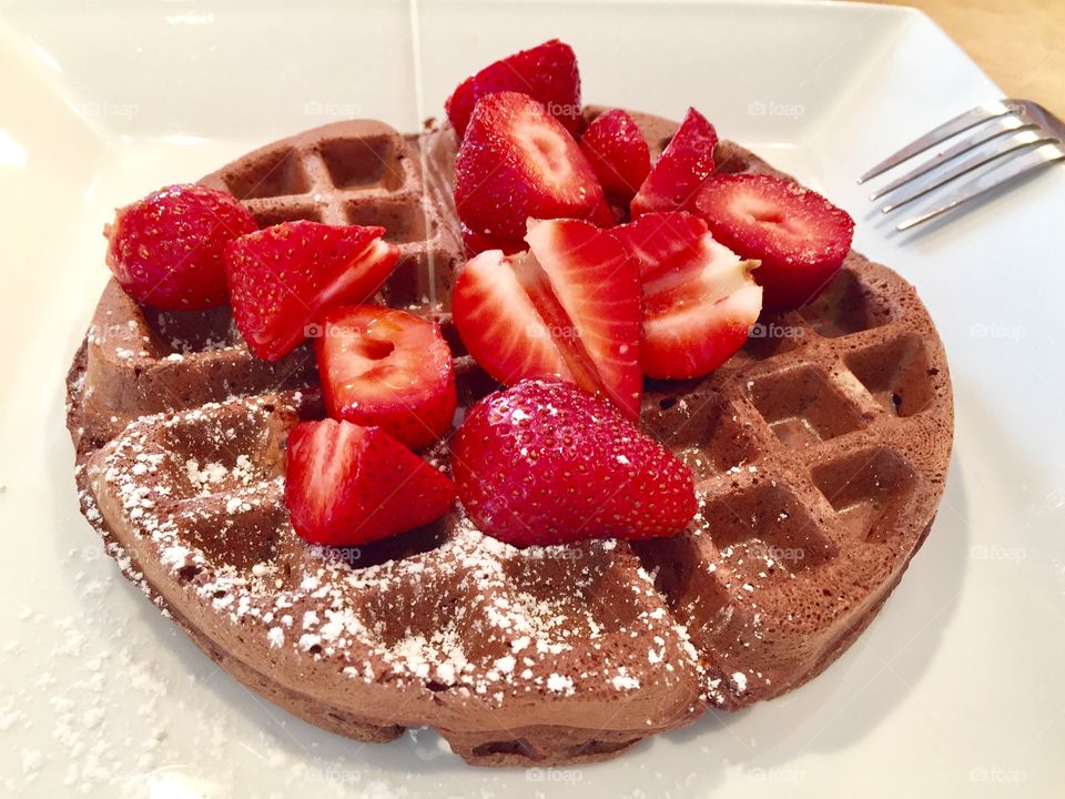 Homemade breakfast. Organic Chocolate Bourbon Vanilla Almond Flaxseed with Coconut Flakes Waffle topped with organic fresh strawberries & drizzled with dark organic maple syrup