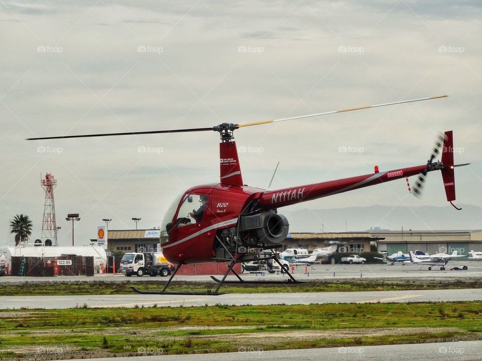 Helicopter Preparing For Takeoff. Robinson R-22 Helicopter In A Hover
