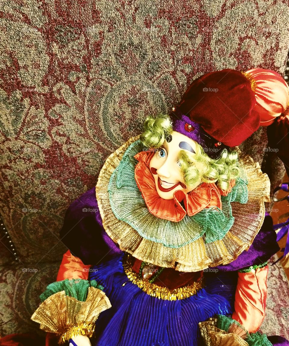 Colorful Clown on Old Chair Looking Away From Camera