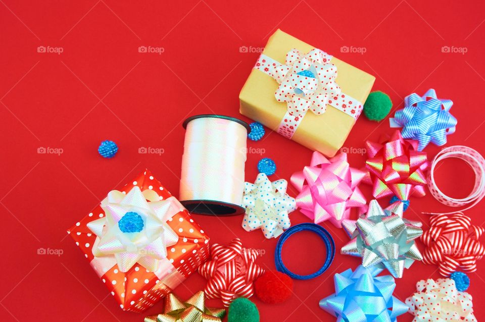 Crafts supplies with gift box,colorful ribbons on red background 