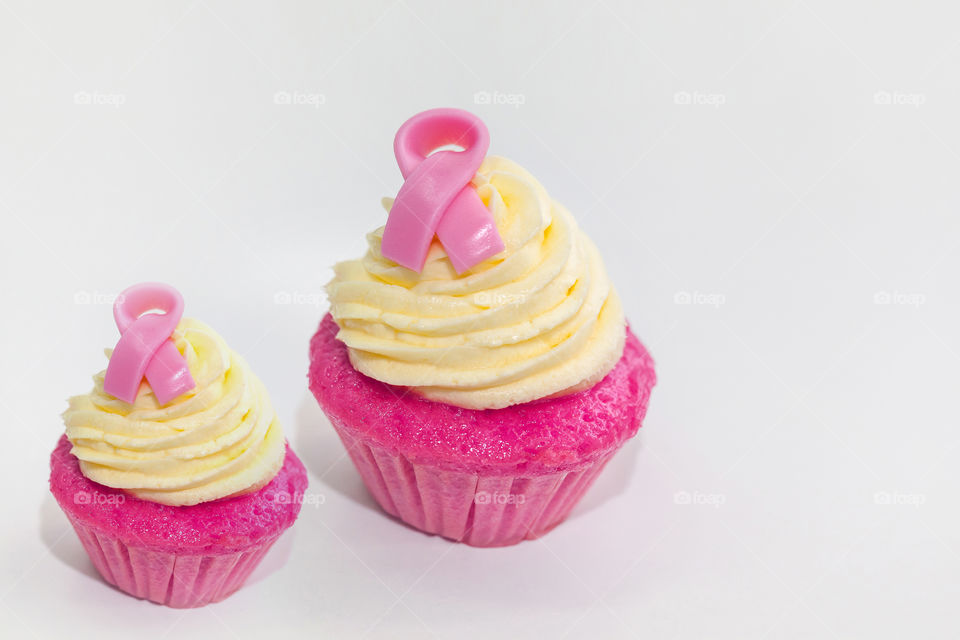 Pink cupcakes isolated on white background. Breast cancer awareness concept.