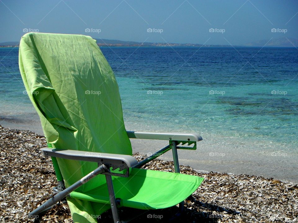 Green color story: green sea deckchair in front of sea