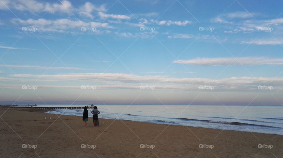 two girls looking at the sea