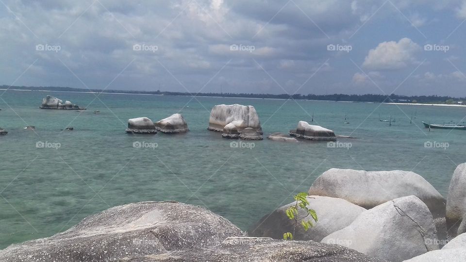 The rocks on the shore and the waters near the coast, white rocks with a smooth texture.