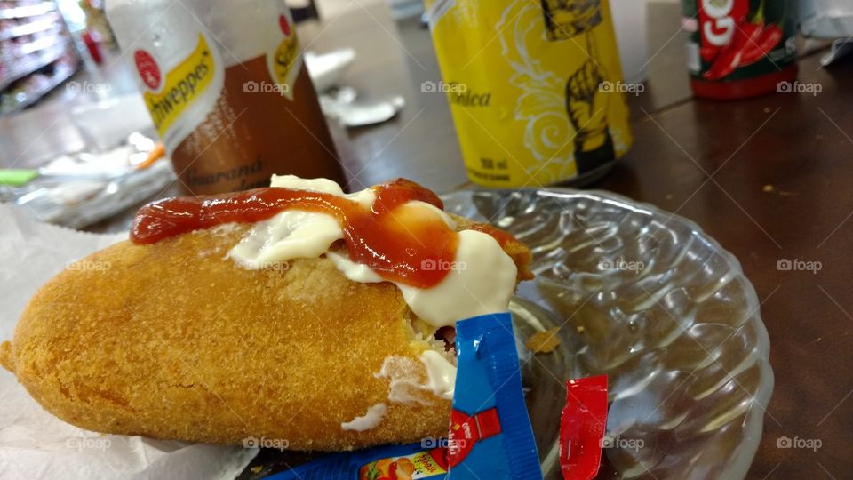 Salgado com maionese, catchup e refrigerante.