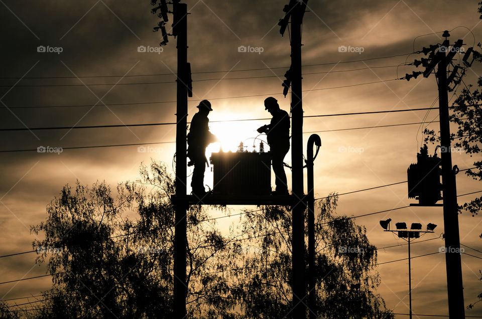 Electricians connecting a transformer