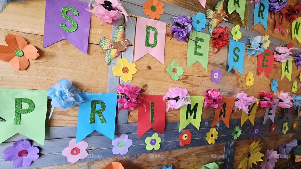 wooden wall with paper flowers and spring message