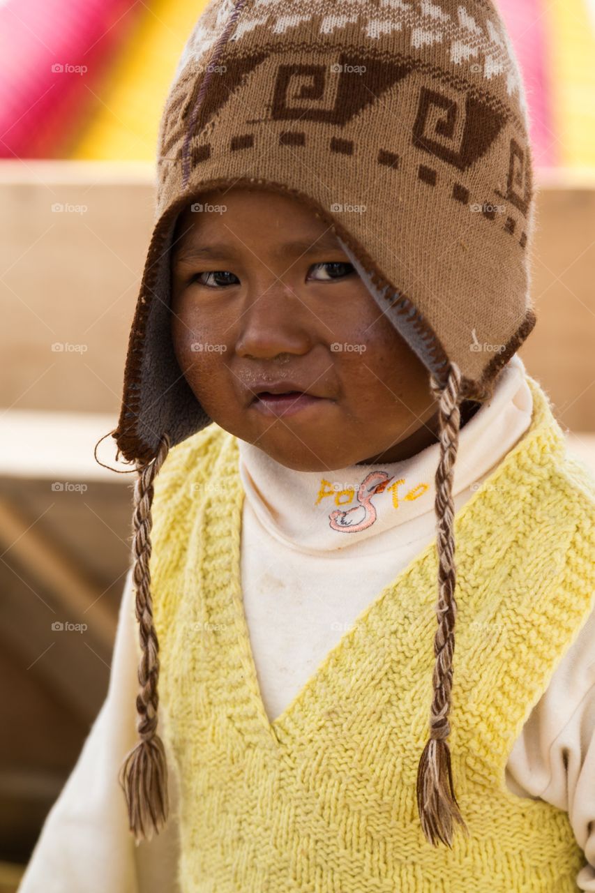Peruvian boy posing for camera. Little Peruvian boy poses for camera.  Traditional hat. Bright colors. Shy.