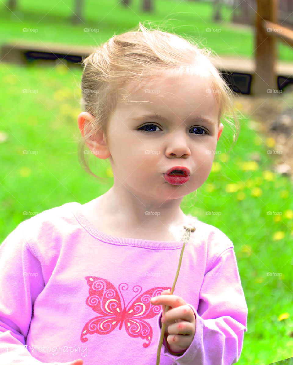 Cute girl holding dandelion