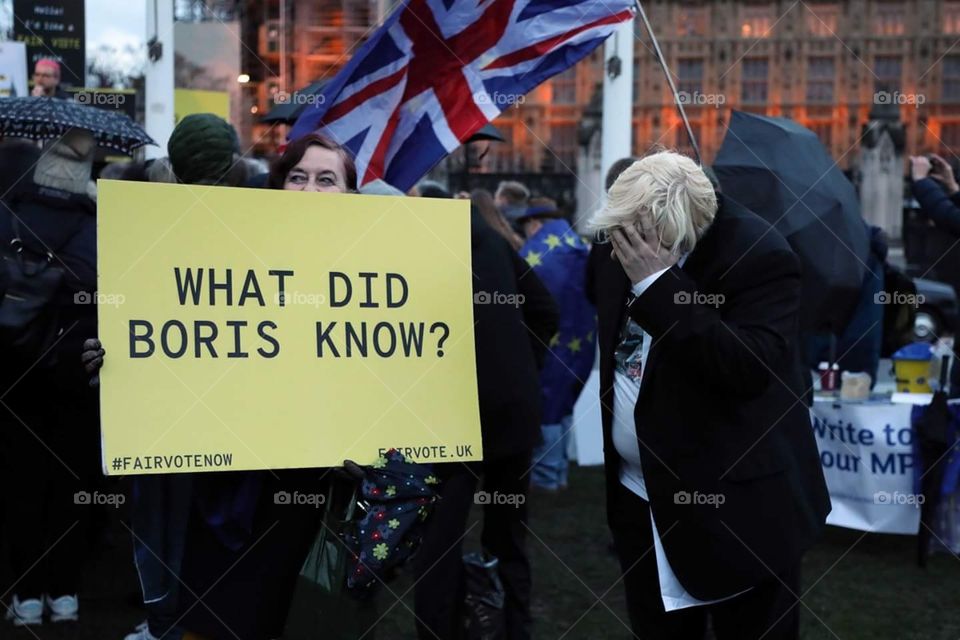 A Boris Johnson impersonator holds his head in his hand at an anti-Brexit demonstration outside the UK Houses of Parliament in central London.