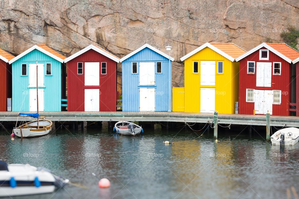 Colorful wooden boathouses on the Smogen pier on the Swedish west coast by the Ocean 