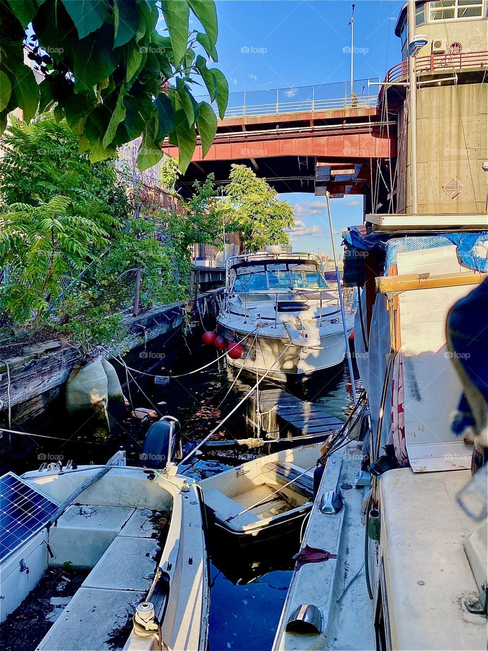 This is “Newtown Creek” by the “Pulaski Bridge” that can be seen in the background. All sorts of boats are tied to the shore here from sailboats to houseboats. 2023. Hypnotic Productions
