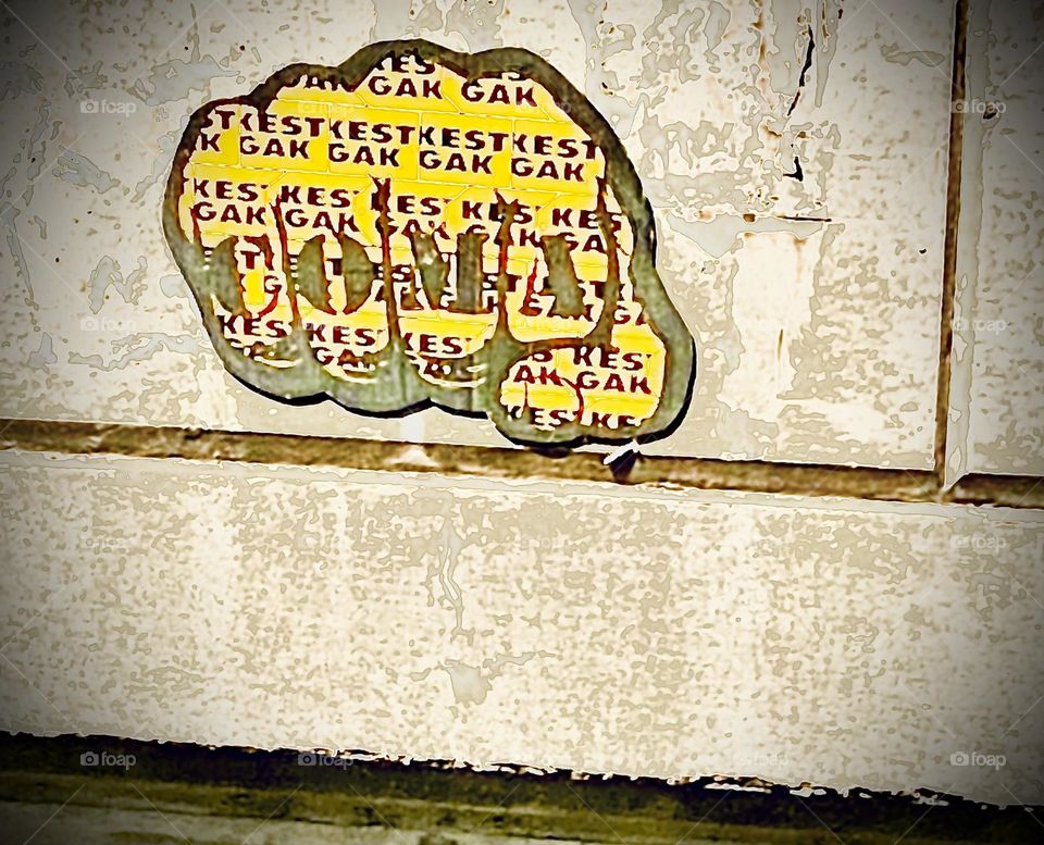 “COMA” says the inscription on the Graphic Design rendition of the knuckles of a balled fist ready to knock someone into a state of unconsciousness when done forcefully enough, hopefully not a “coma” Found in LIC, Queens. 2022. Hypnotic Productions