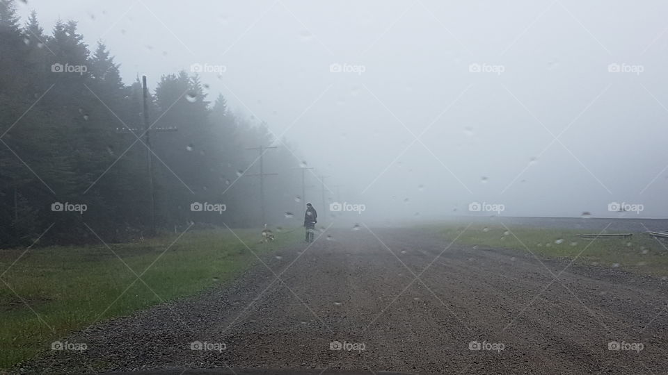 foggy morning, man and his dog walking together