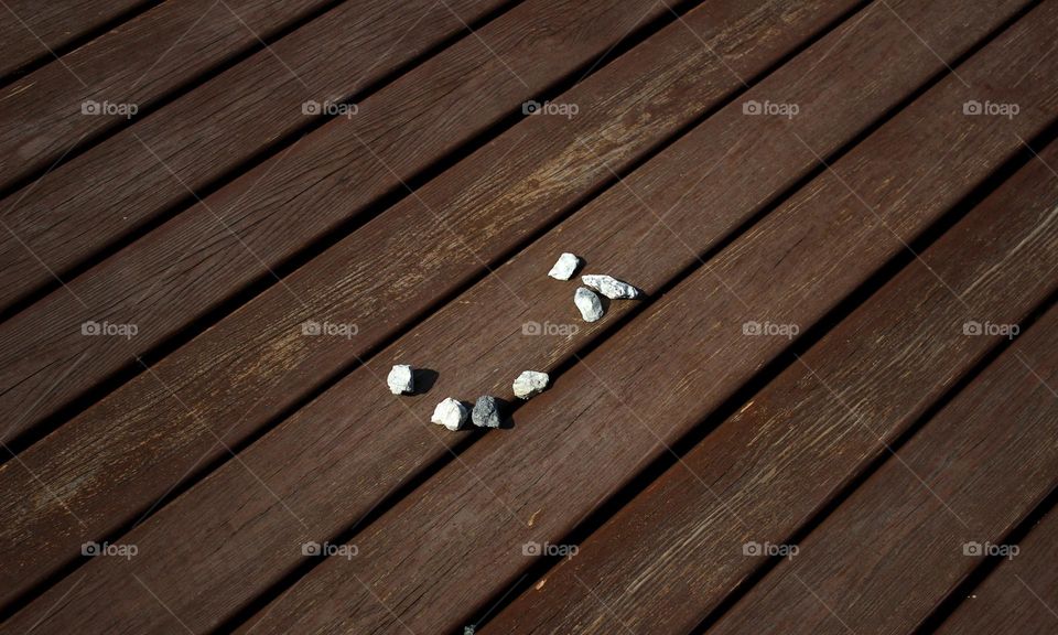 Chaotic tiny rocks on brown wood 