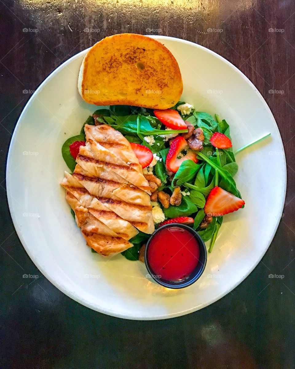 Plated Grilled Chicken Strawberry Spinach Salad with Raspberry Vinaigrette Dressing with Candied Walnuts, Feta Cheese and Garlic Toast 