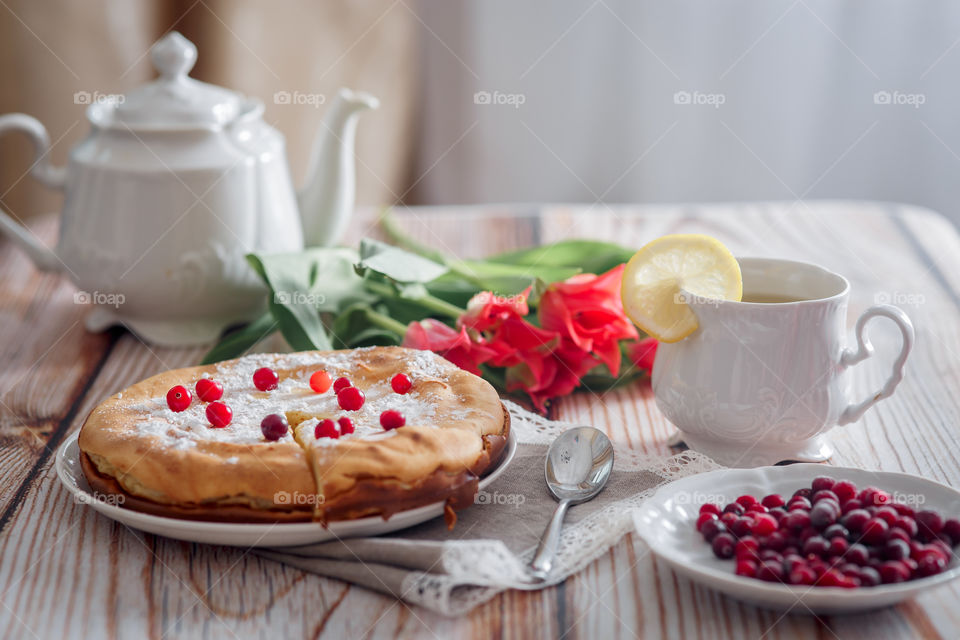 Cheesecake with cranberries and sugar on wooden background