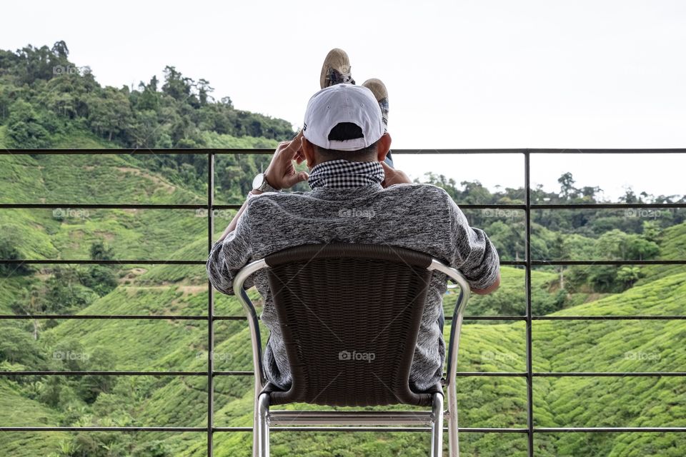 A man take a rest with morning coffee at the beautiful tea plantation