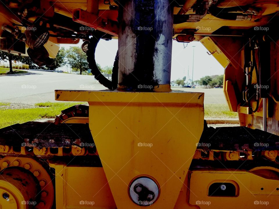 A closeup look at the under belly of a large construction machine.