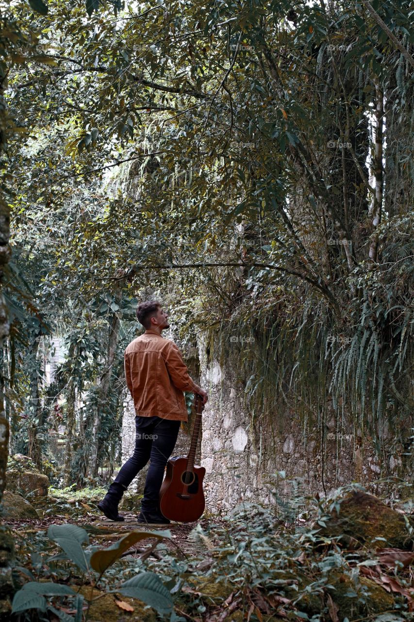 A man playing guitar in nature