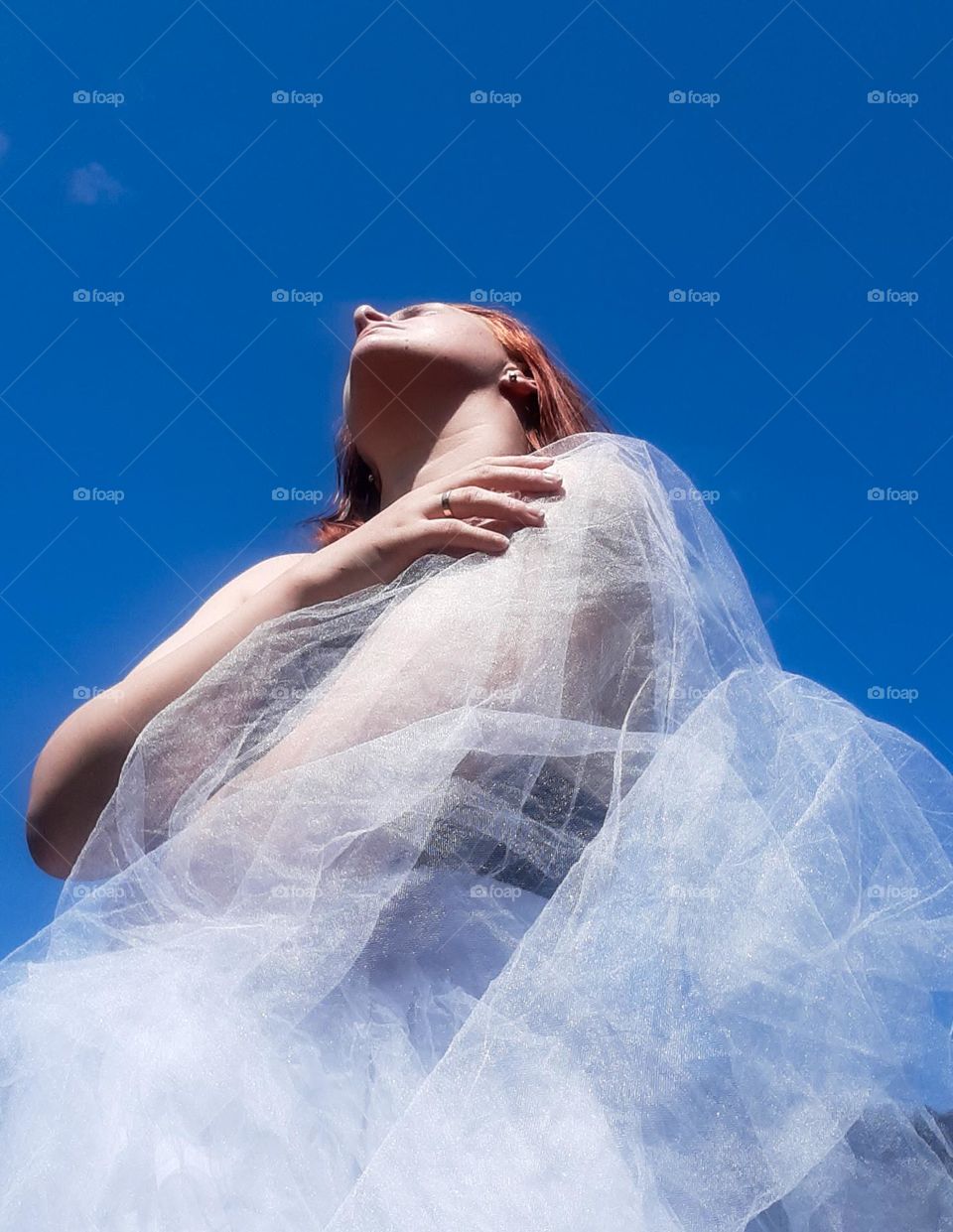 original photo of a girl enjoying the spring air against the background of the blue sky