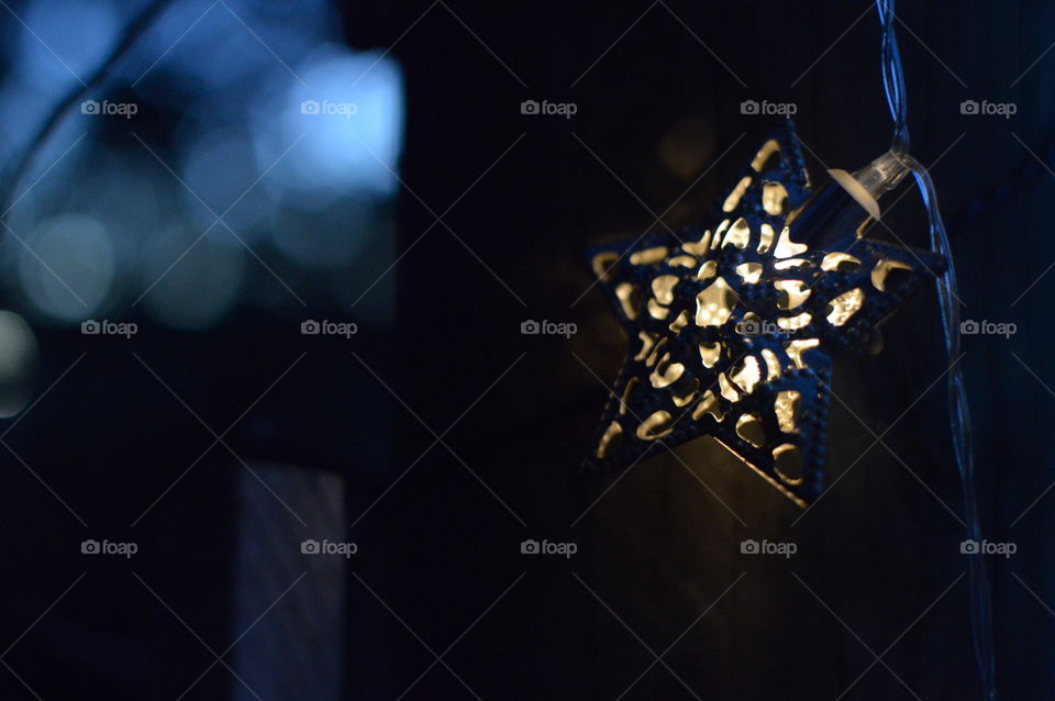 Bright shining star with blue bokeh effect in background.