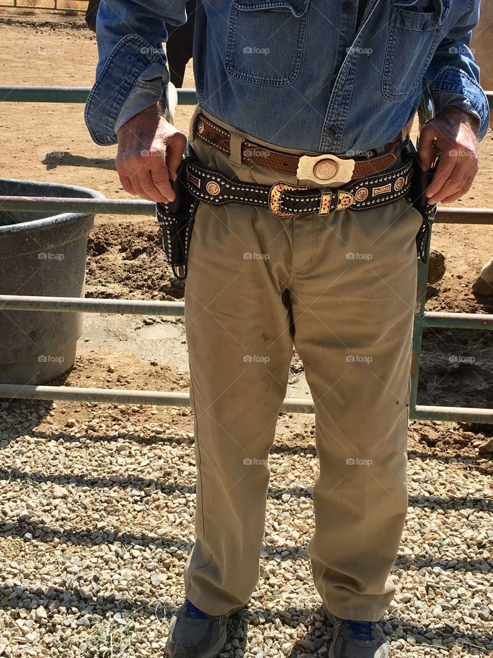 Old senior cowboy wearing fun holsters and belt 