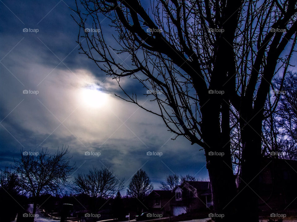 The sun trying to peer through the dark clouds.