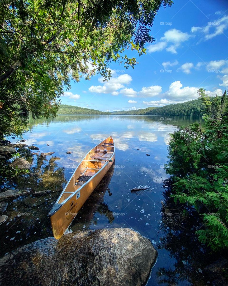 A yellow canoe sits at the portage to a wilderness lake 