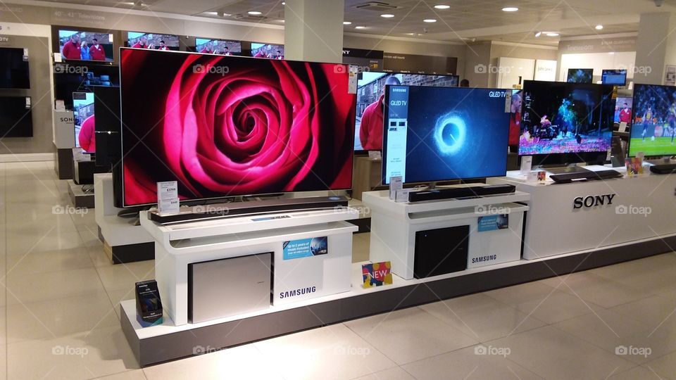Samsung QLED television 4K UHD TV displayed with Samsung soundbars and wireless sub-woofers