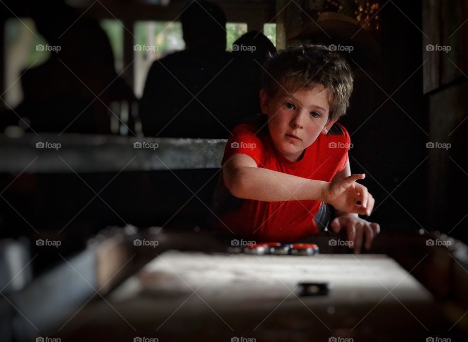 Shuffleboard. Boy Playing Table Hockey
