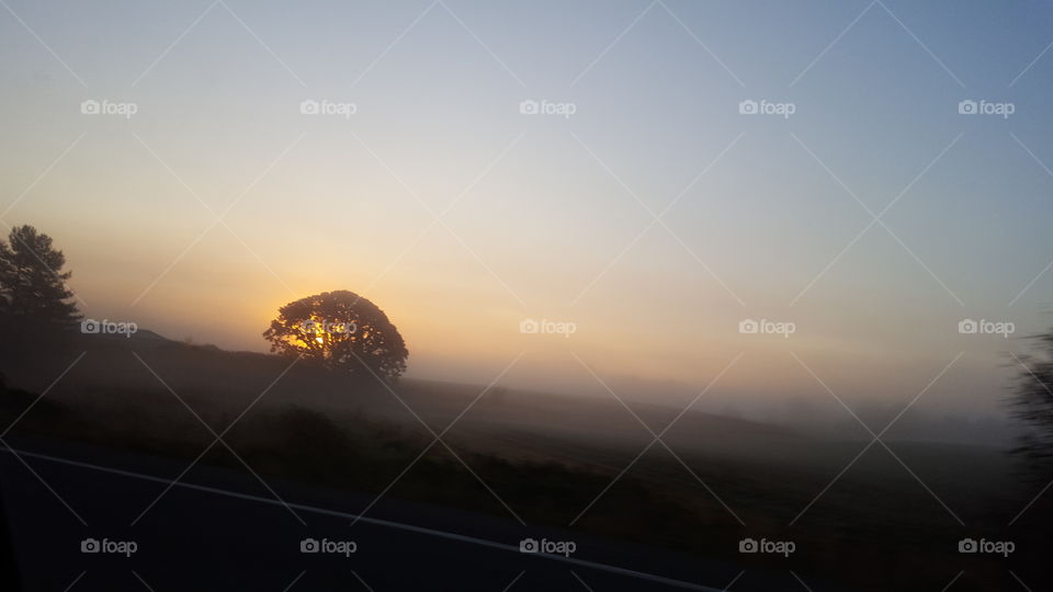 sun coming up over valley