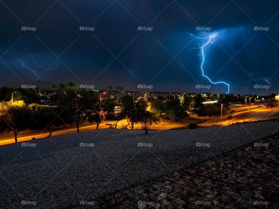 A bright lightning bolt shoots from the sky to the earth during a Arizona haboob
