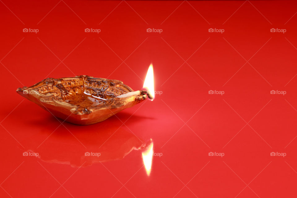 Indian festival Diwali diya oil lamp on red