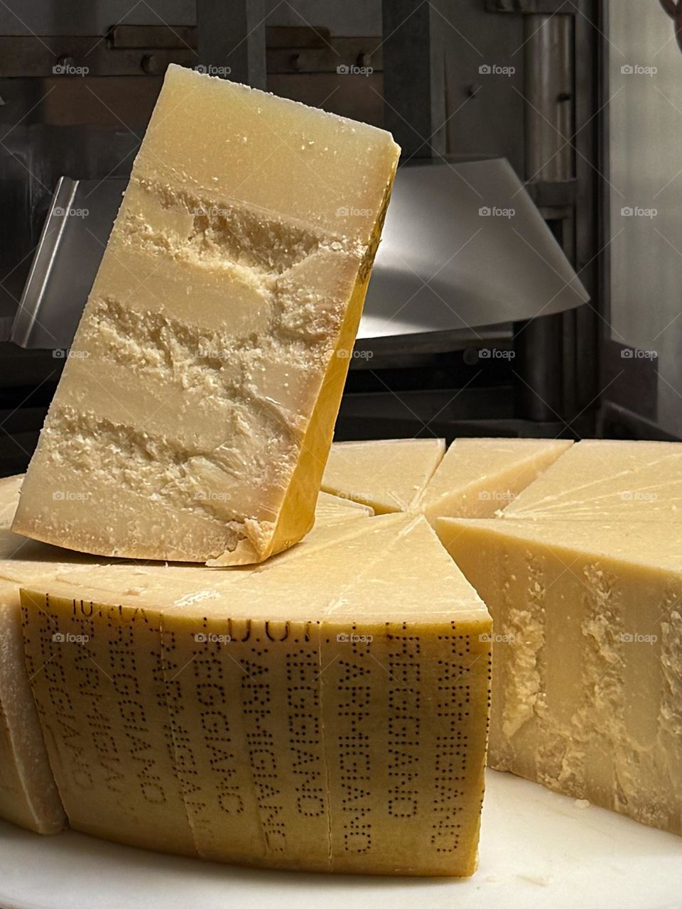 Parmesan cheese wheel cut in big pieces, nice clear cheese textures, the process of cutting a big cheese wheel in Italy, Parma