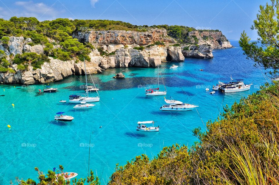 amazing cala macarella top view on menorca balearic island in spain - rocks, transparent water, yachts and boats