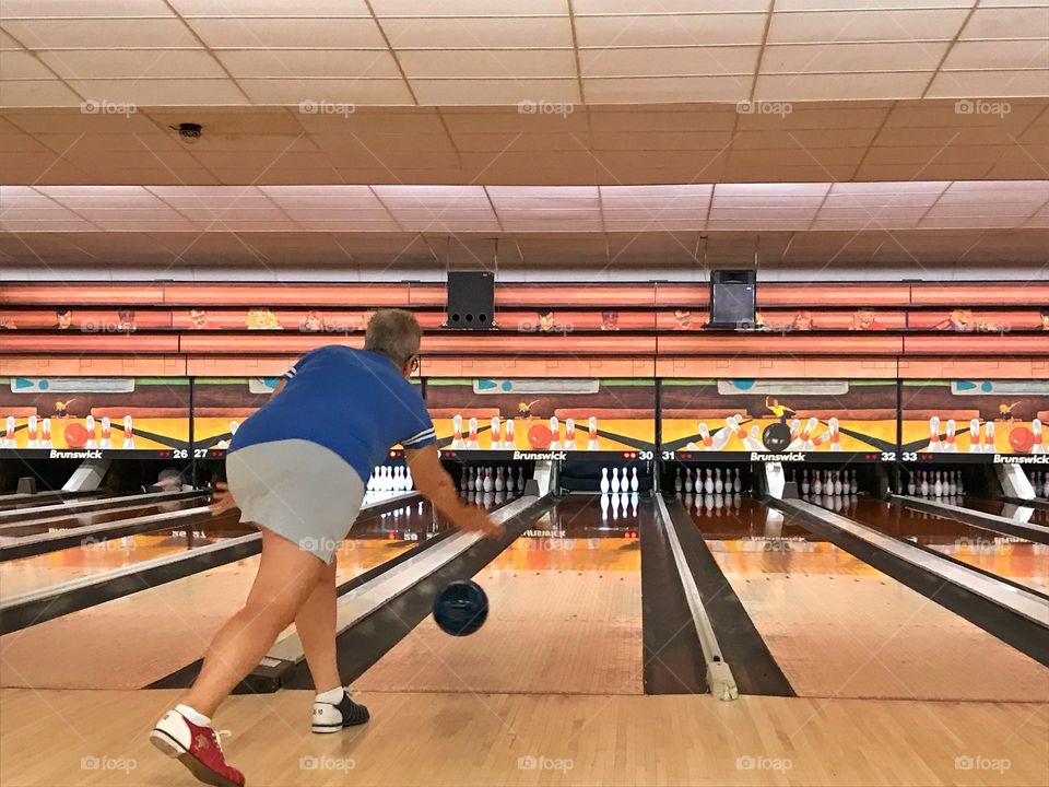 Woman bowling in bowling alley