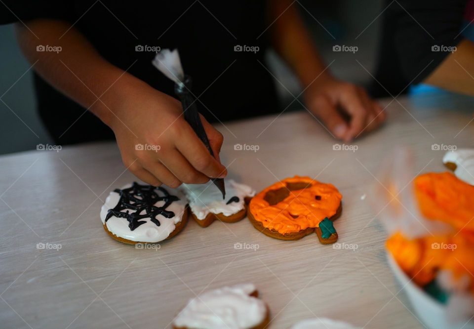 seven year old boy decorating handmade cookies for Halloween