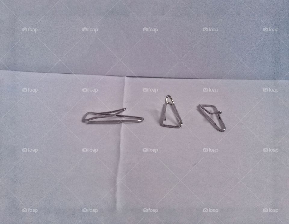 paper clip are seen from various angles made of metal and are widely used to bring together paper files