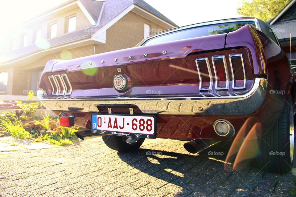 Oldtimer ford mustang. An oldtimer ford mustang during golden hour at sunset.