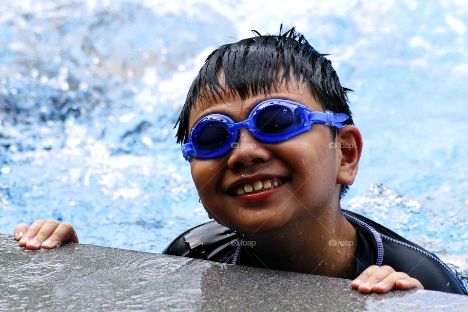 young boy with goggles in a swimming pool