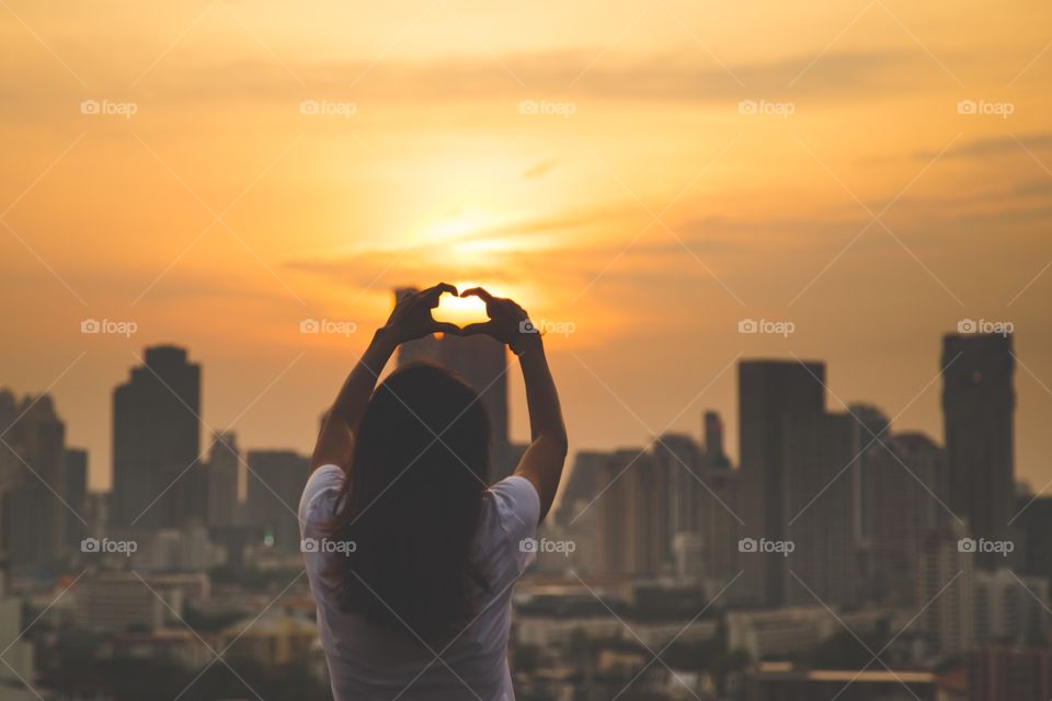 Rear view of a woman making heart shape