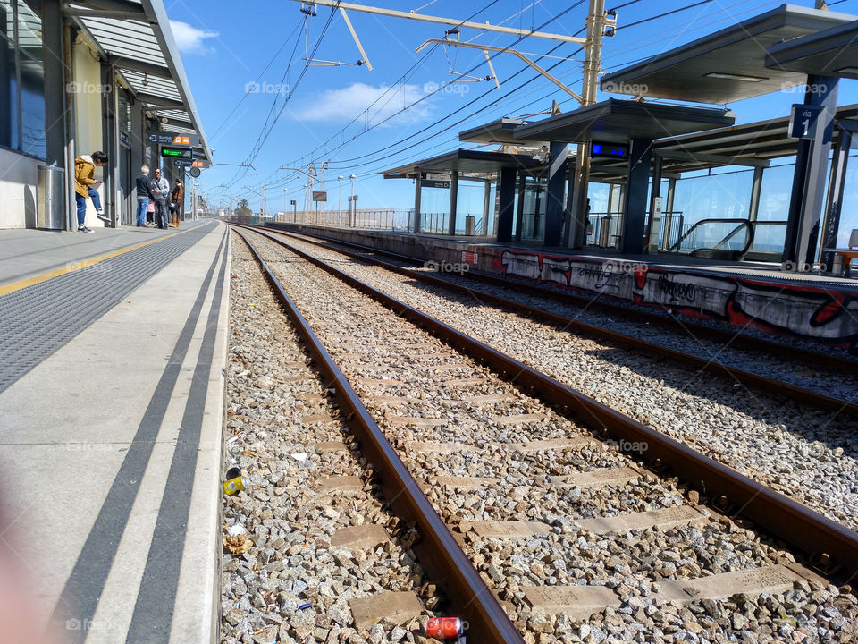 foto a las vías del tren en la estación. esperando el tren en un bonito día para ir a Barcelona a dar un paseo