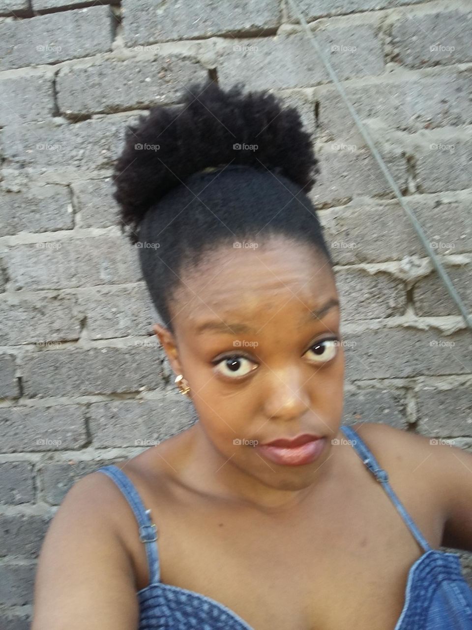 Black Woman with natural hair tied in a puff